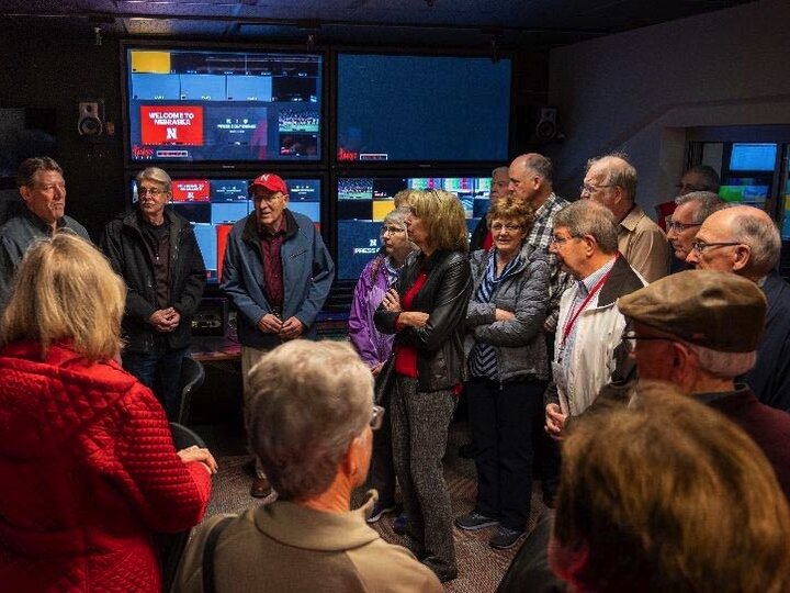 era members are standing in a circle around a speaker in the HuskerVision facility